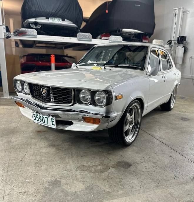 a white car with a license plate that says 36907 e is parked in a garage .