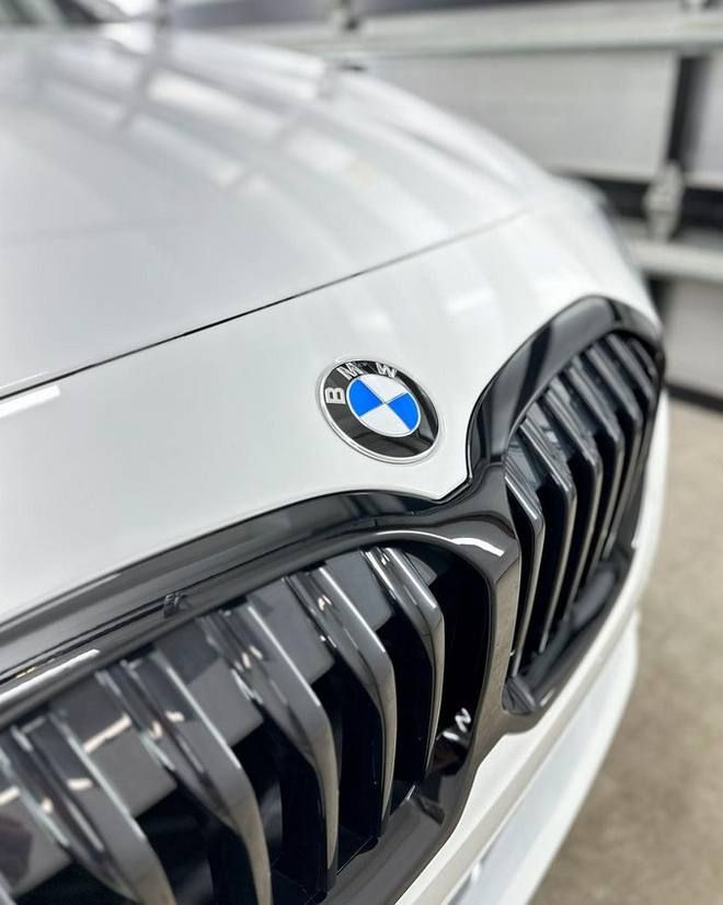 a close up of a white bmw with a black grille, where a ceramic coating has been applied