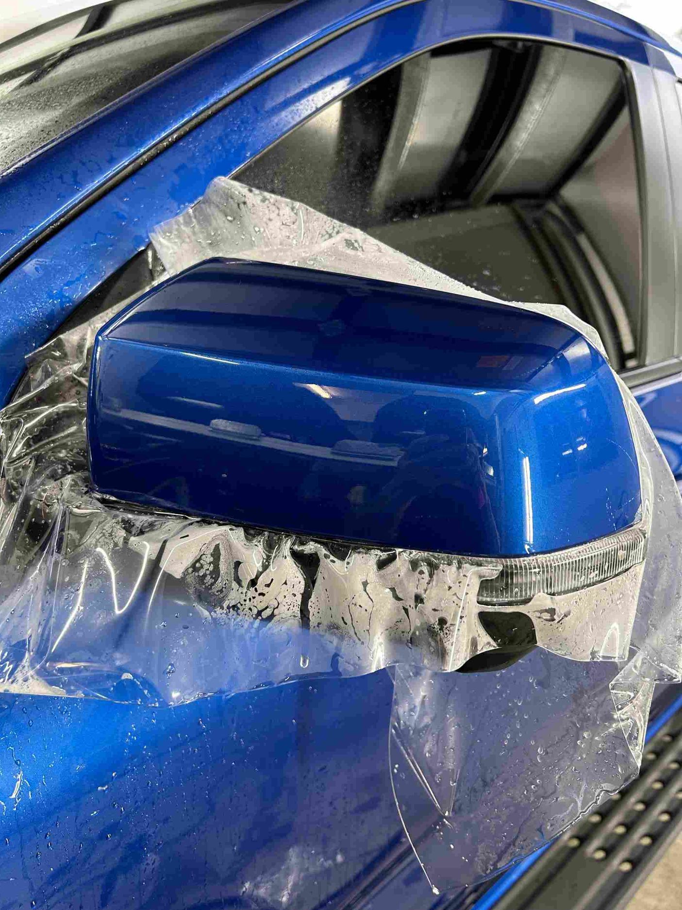 a person is wrapping a car in black plastic