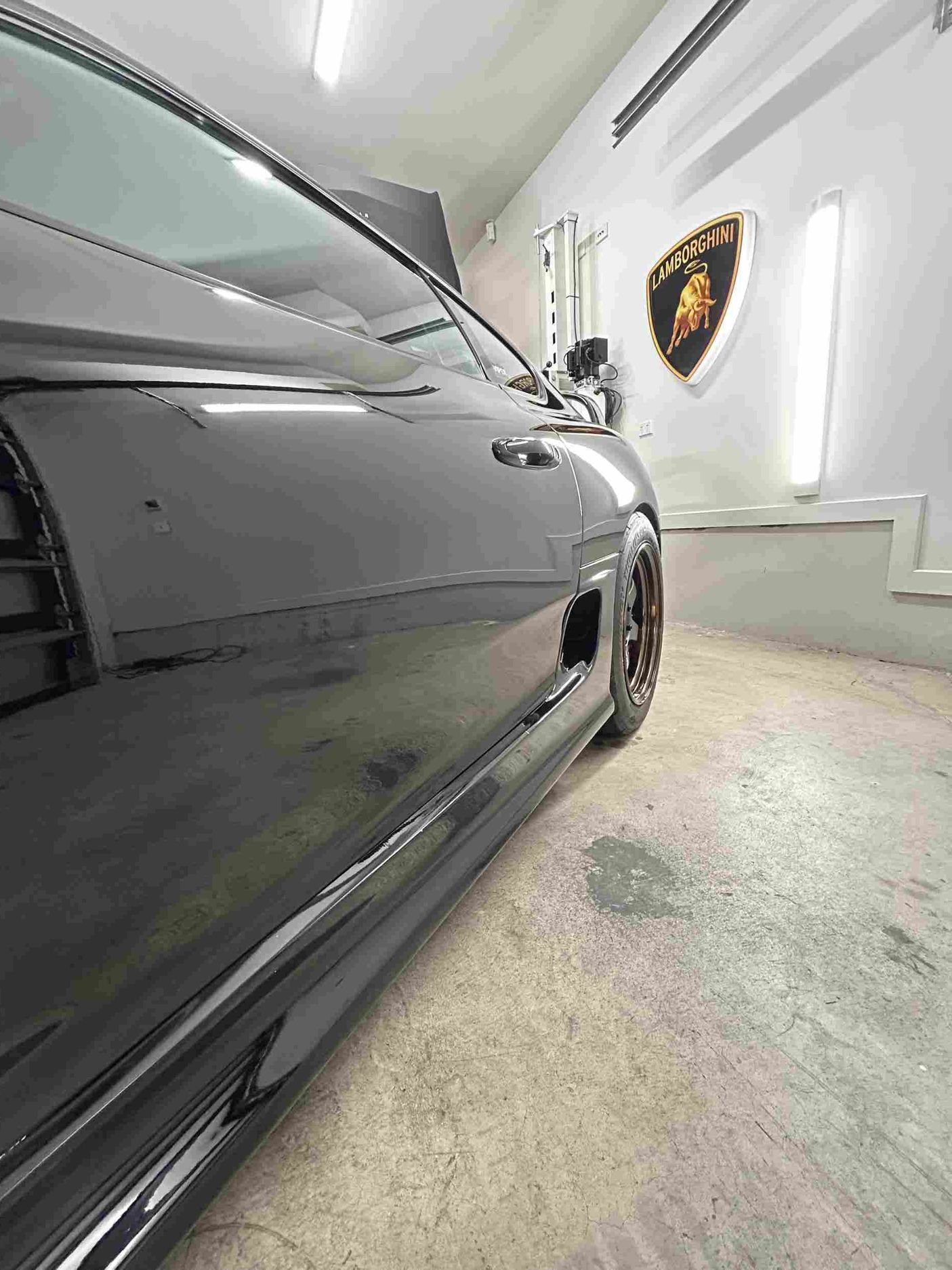 a black mercedes benz is parked in a garage after a ceramic coating paint protection has been applied in castle hill
