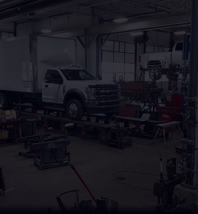 A truck is being worked on in a garage. | Beacon Auto Repair Center
