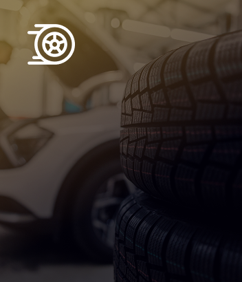A stack of tires with a car in the background | Beacon Auto Repair Center