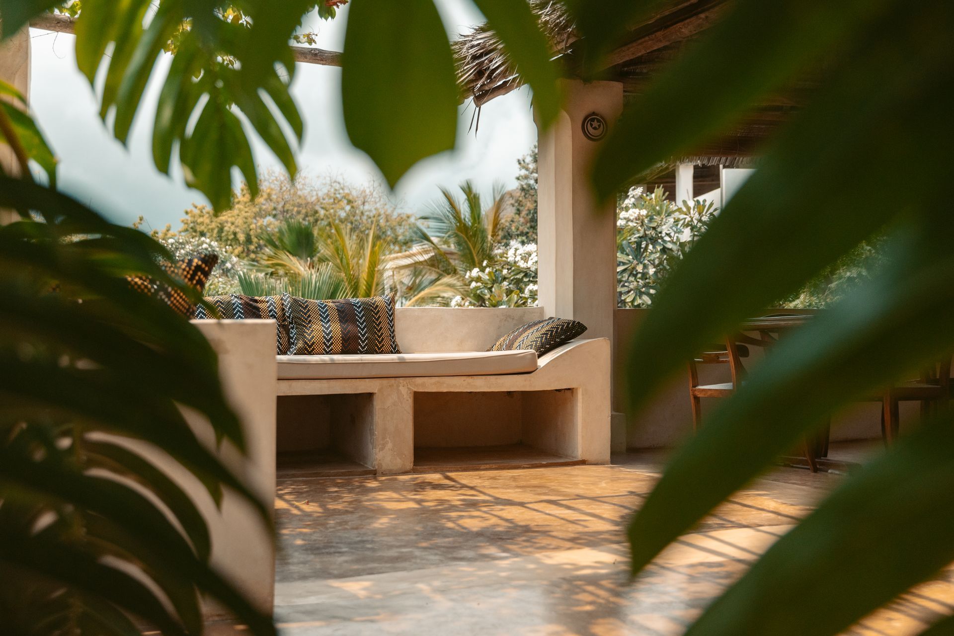 utdoor lounge area surrounded by palm trees and Monstera's