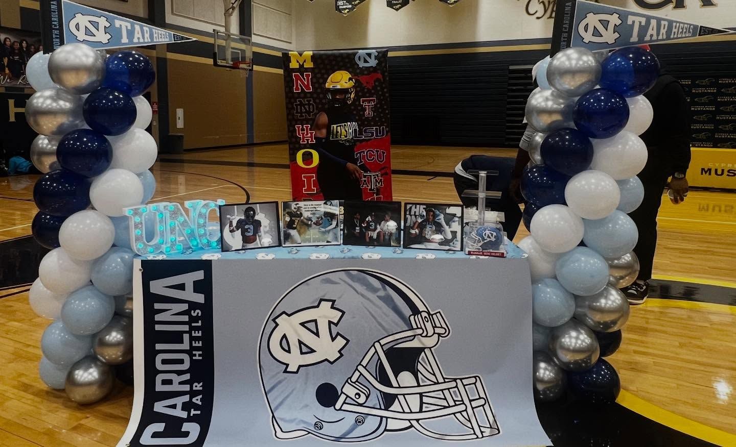 North Carolina basketball-themed table with balloon columns and team logo in a gym