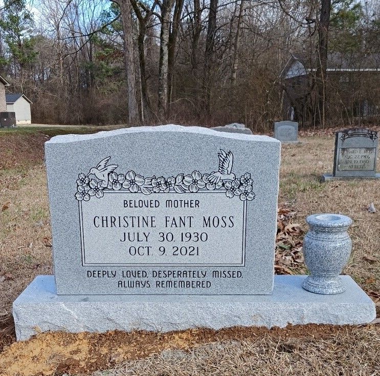 Gray headstone with inscription for Christine Fant Moss (1930-2021) in a cemetery.