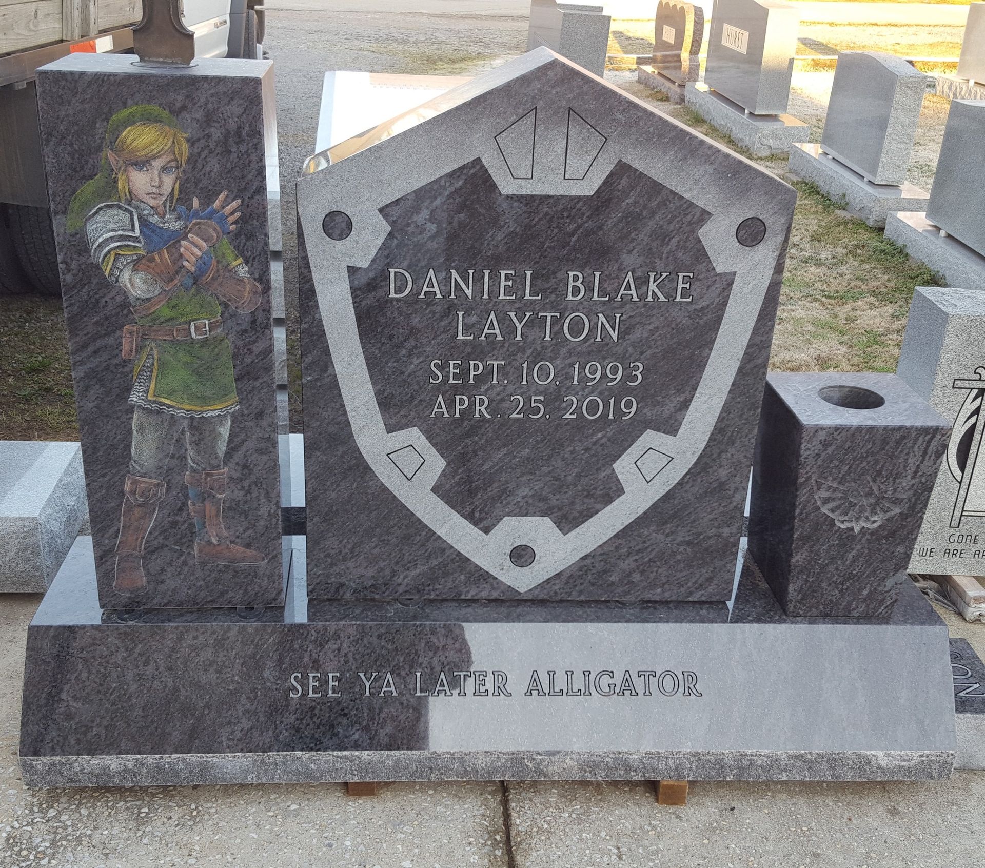Tombstone with Zelda-themed design: Link figure, shield with name, dates, and engraved