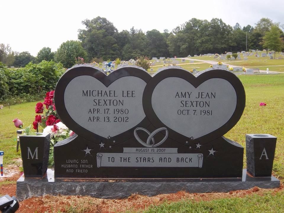 Headstone of a couple, Michael and Amy Sexton, in a cemetery. Two heart-shaped panels with names, dates, and an inscription.