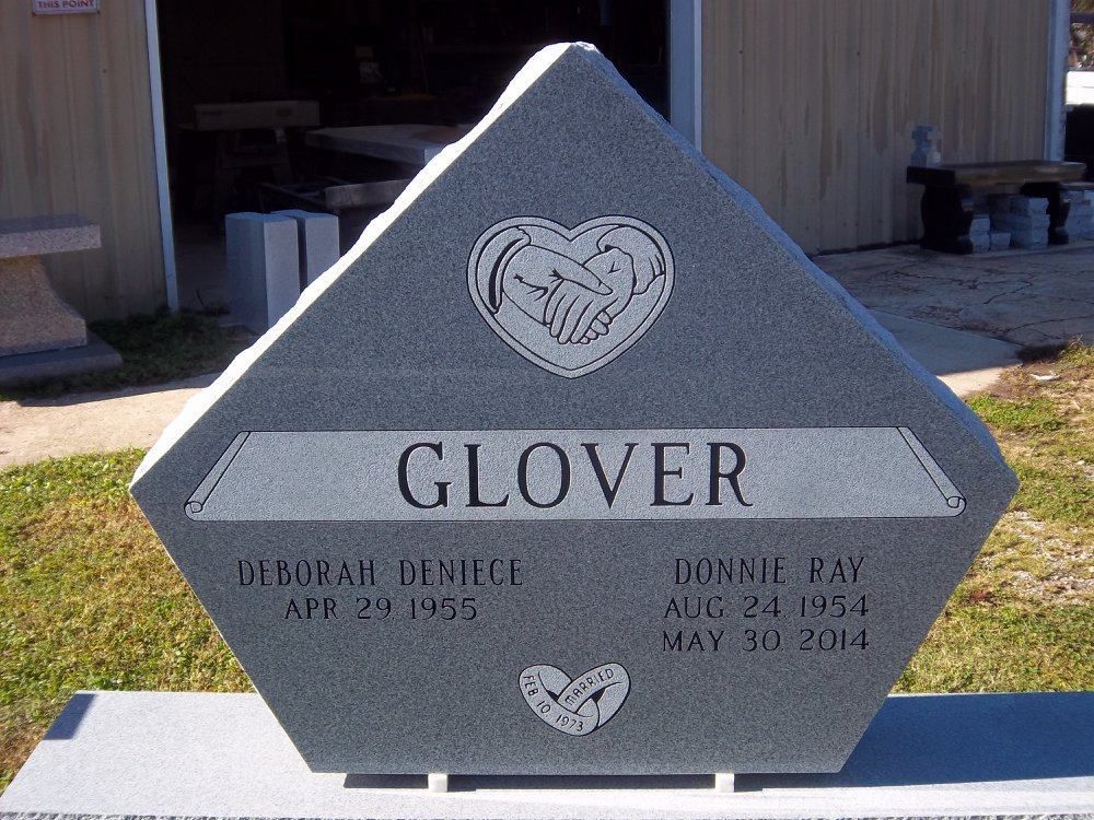 Gray granite headstone, Glover family name, dates, hands in heart symbol.