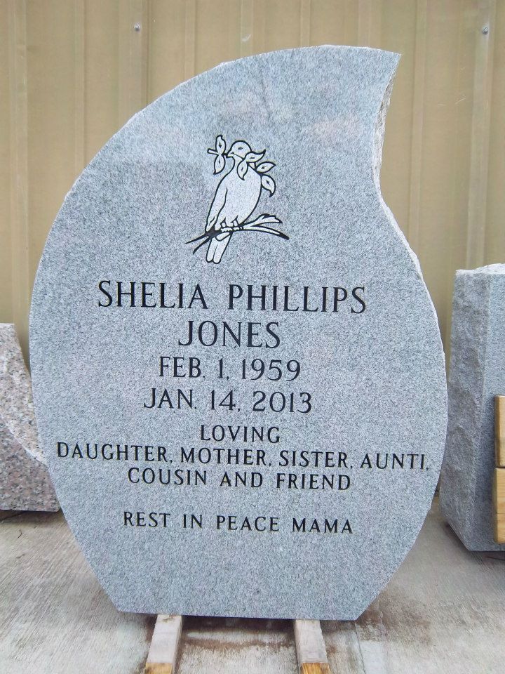 Gray granite headstone with a bird graphic, inscribed with name, dates, and