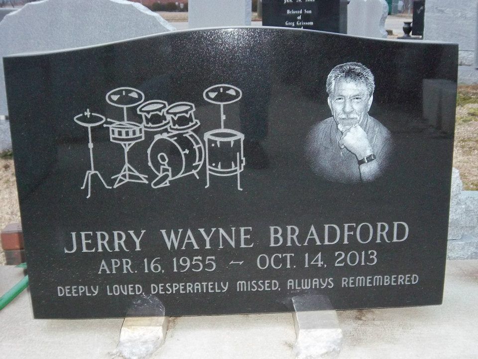 Black tombstone with a drum set, photo, and inscription for Jerry Wayne Bradford, 1955-2013.