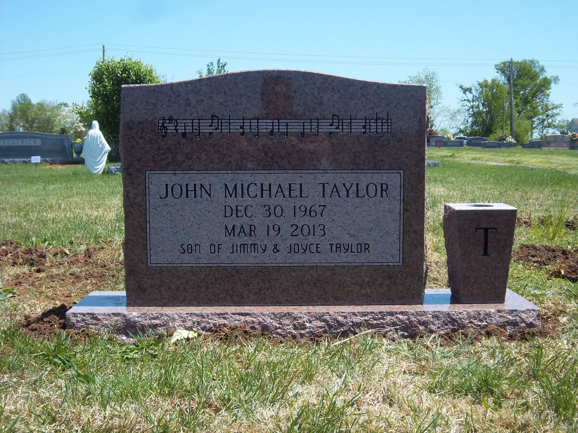 Black tombstone with a drum set, photo, and inscription for Jerry Wayne Bradford, 1955-2013.