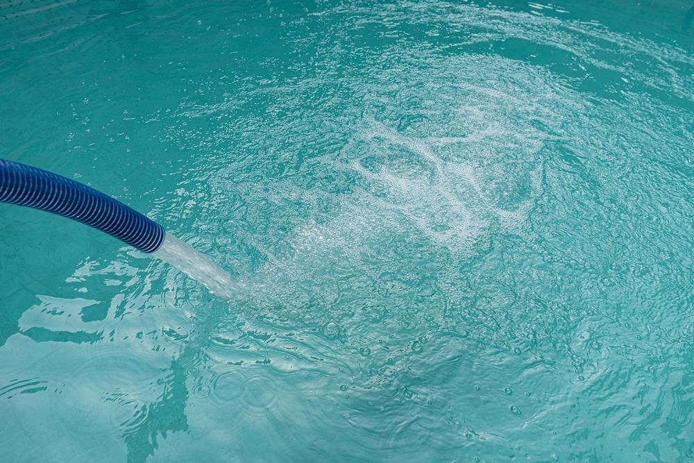 Blue Hose Expelling Water Into a Turquoise Pool — Water TopUps Gympie in Chatsworth, QLD