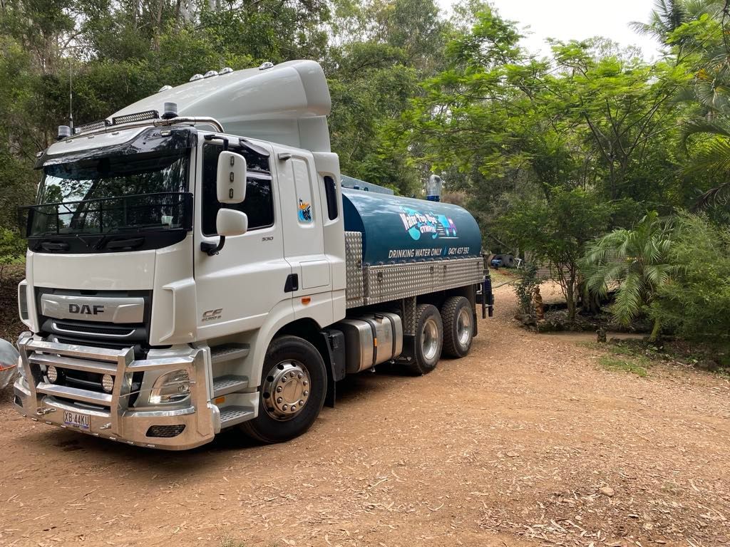 White tanker truck parked on gravel driveway, surrounded by trees. — Water TopUps Gympie in Chatsworth, QLD