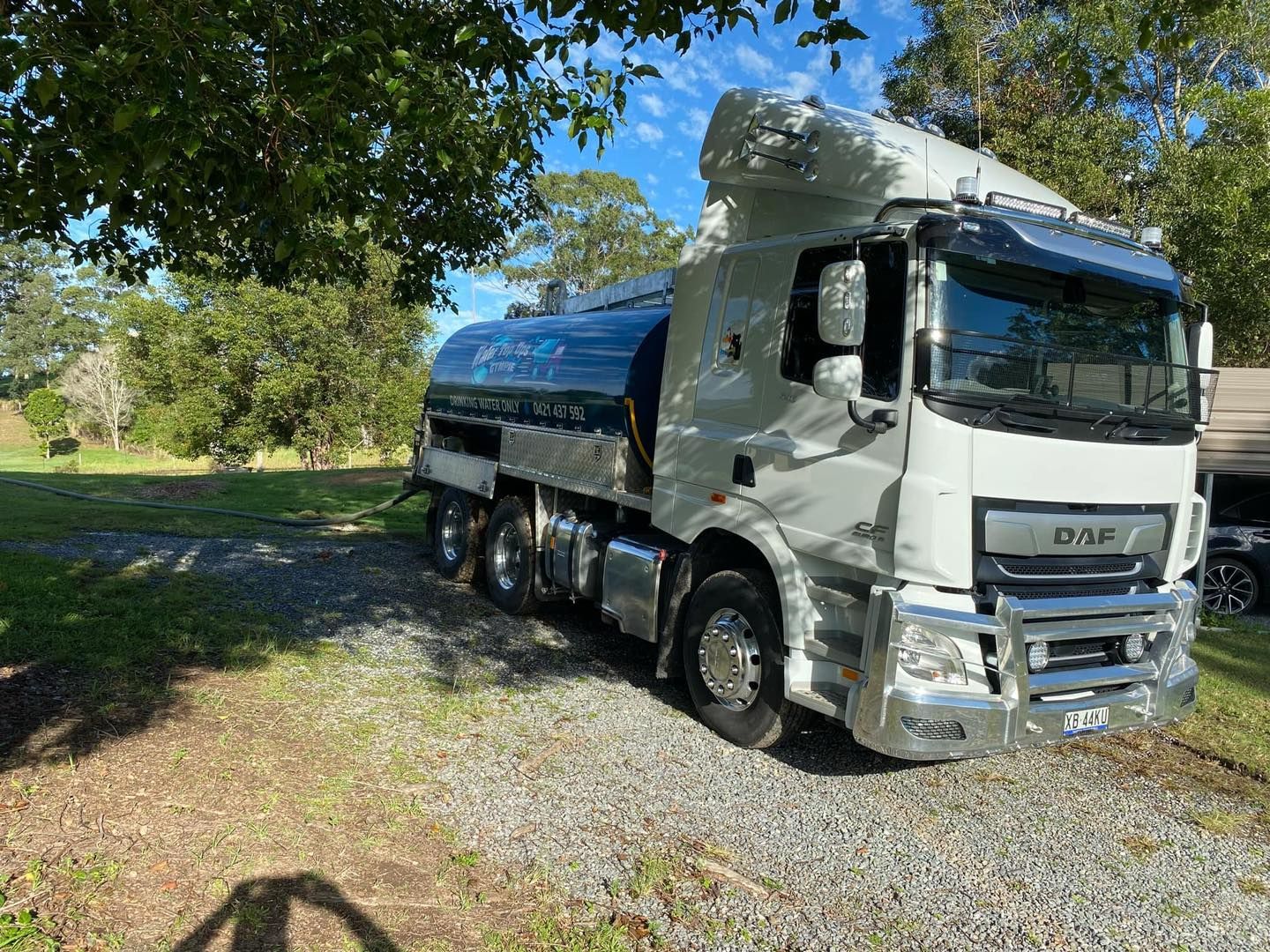 White Tanker Truck Parked on Gravel Next to Grassy Area — Water TopUps Gympie in Chatsworth, QLD