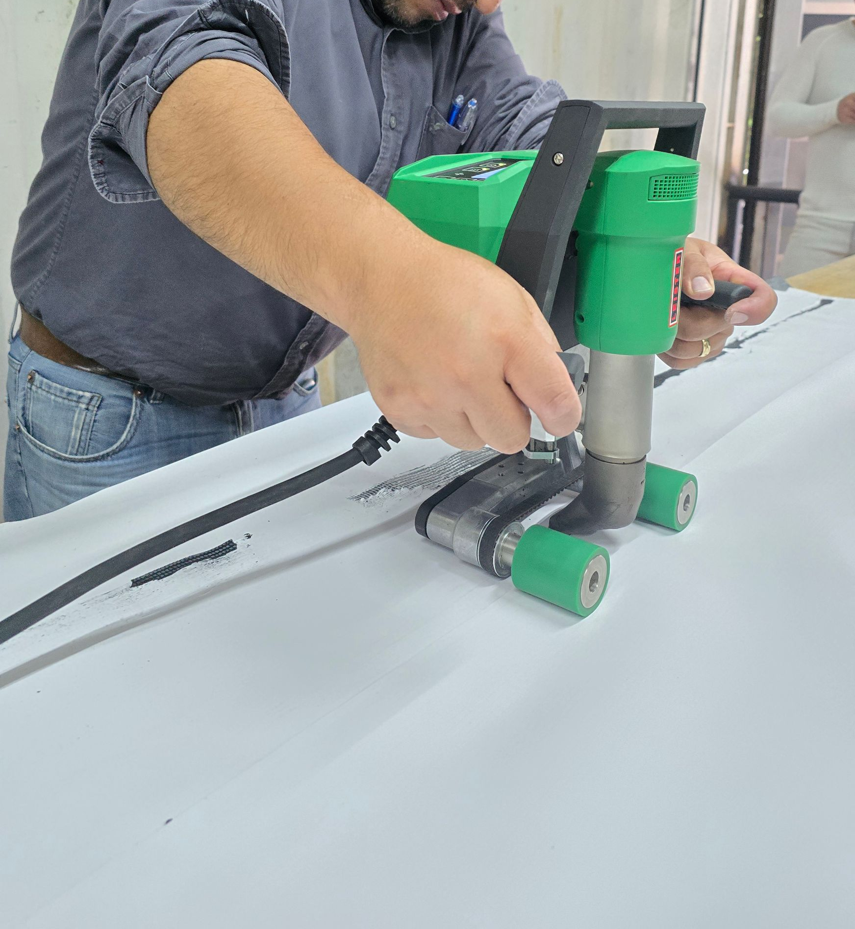 Trabajadores con overoles de color naranja y cascos cortando madera al aire libre.