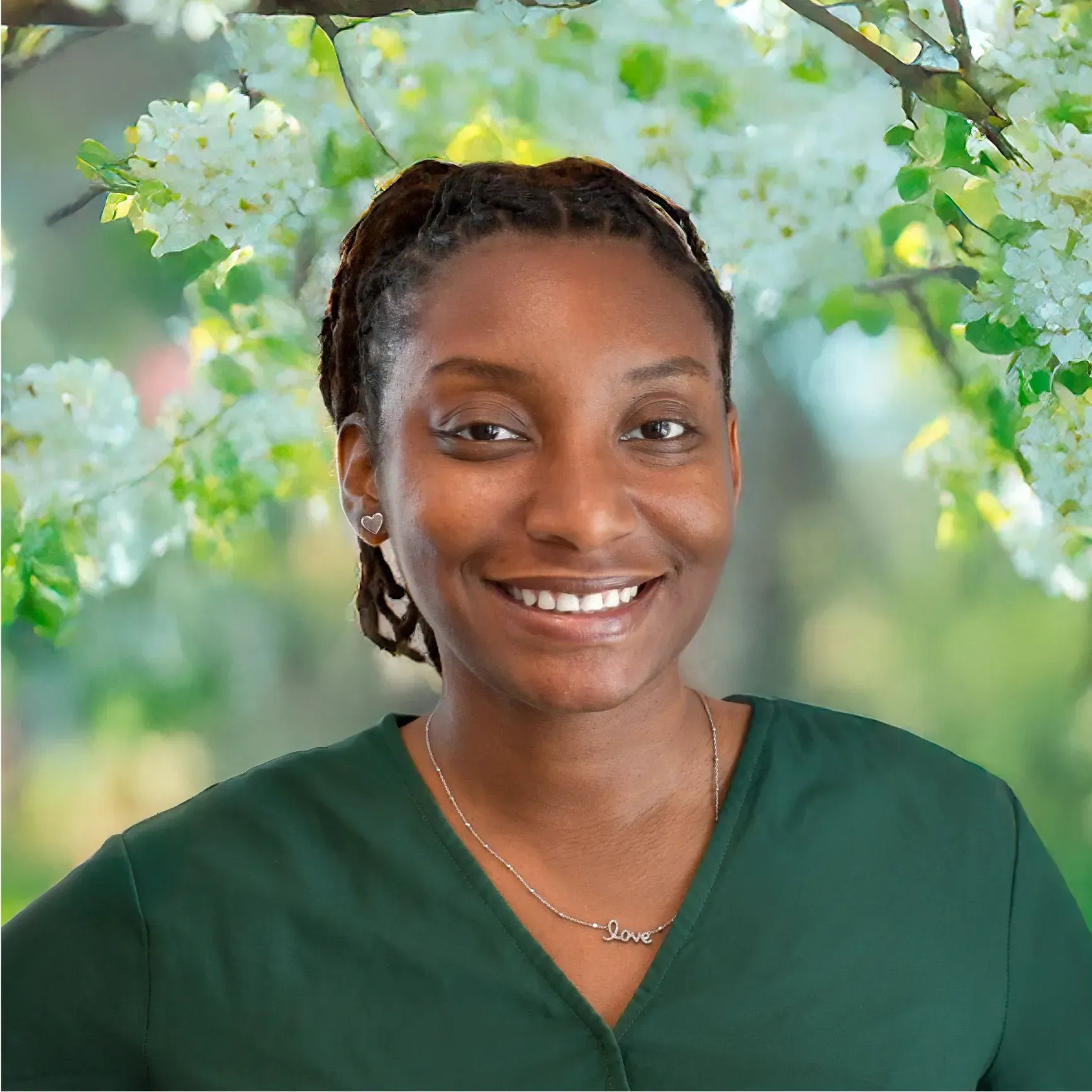 Smiling woman in a green top against a soft floral background