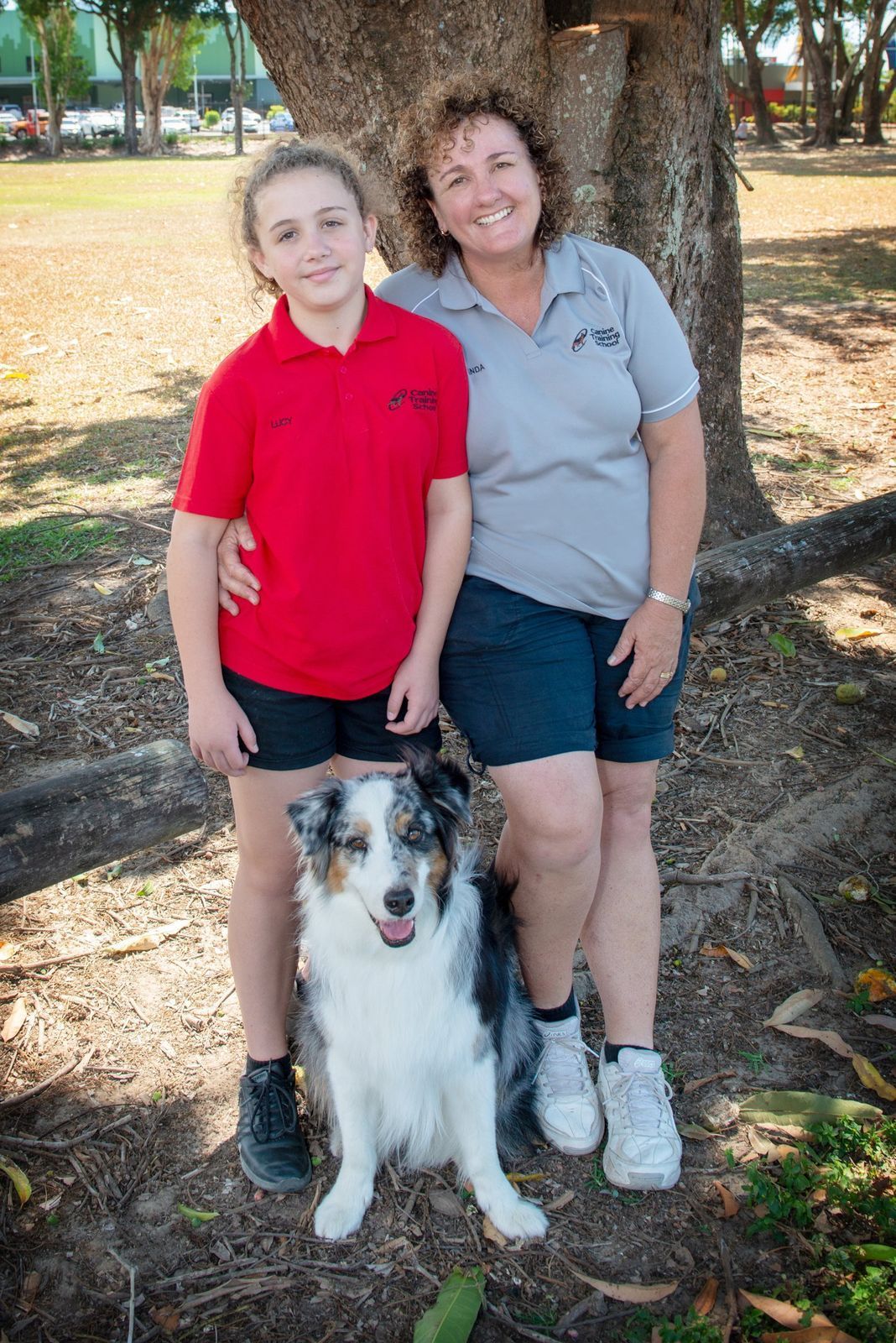 Woman and Child Standing With a Dog in Front of a Tree — Canine Training School in Trinity Park, QLD