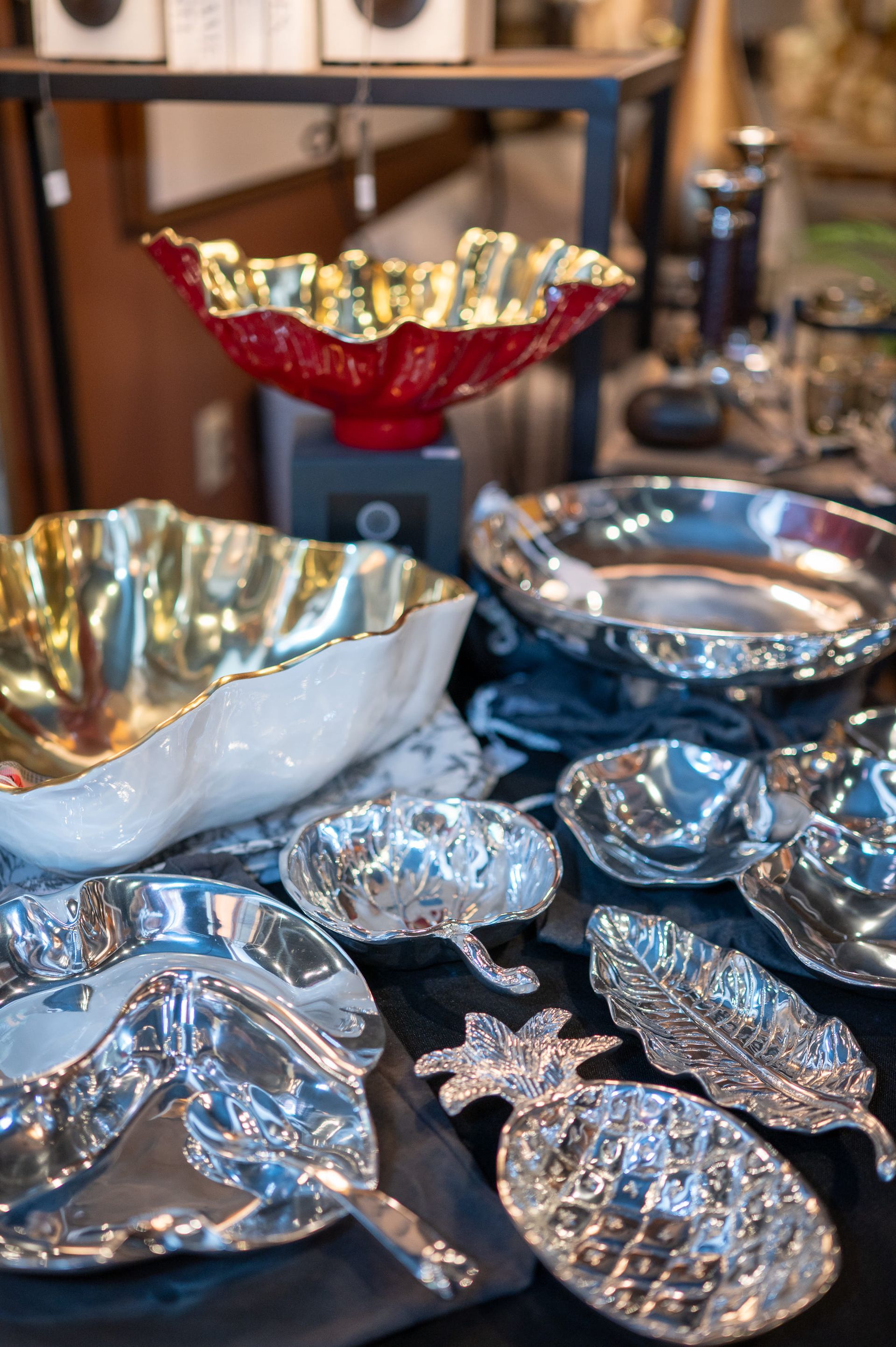 Silver and gold decorative bowls and platters on a table.