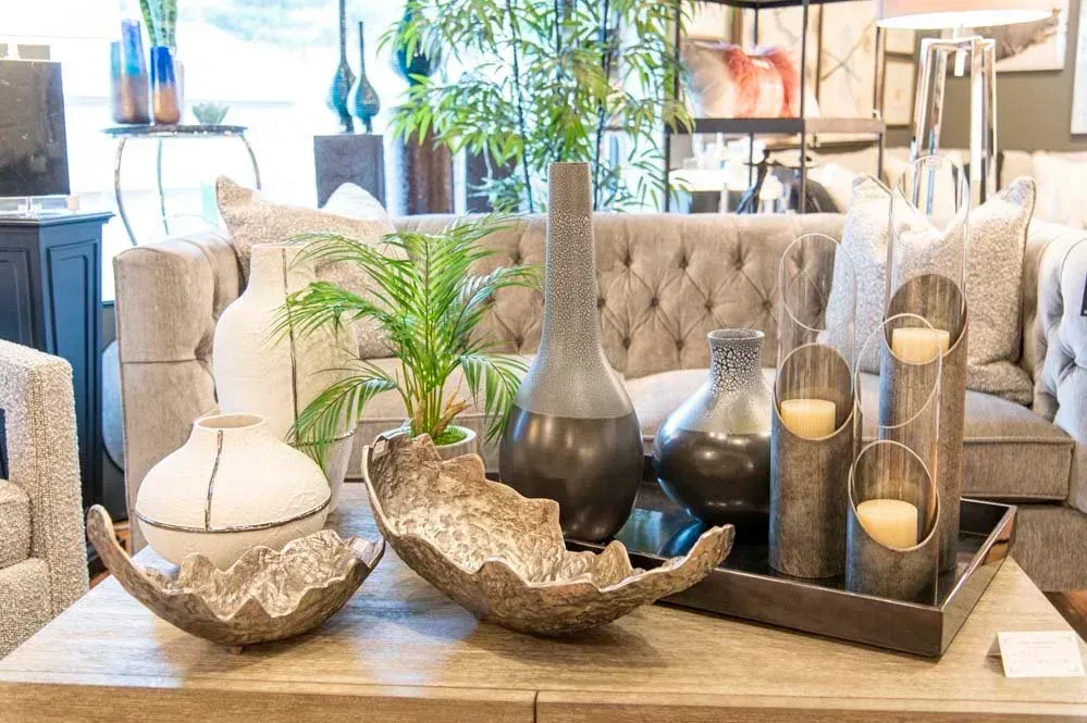 Living room decor: vases, tray with candles, bowl, and small plant on a coffee table.