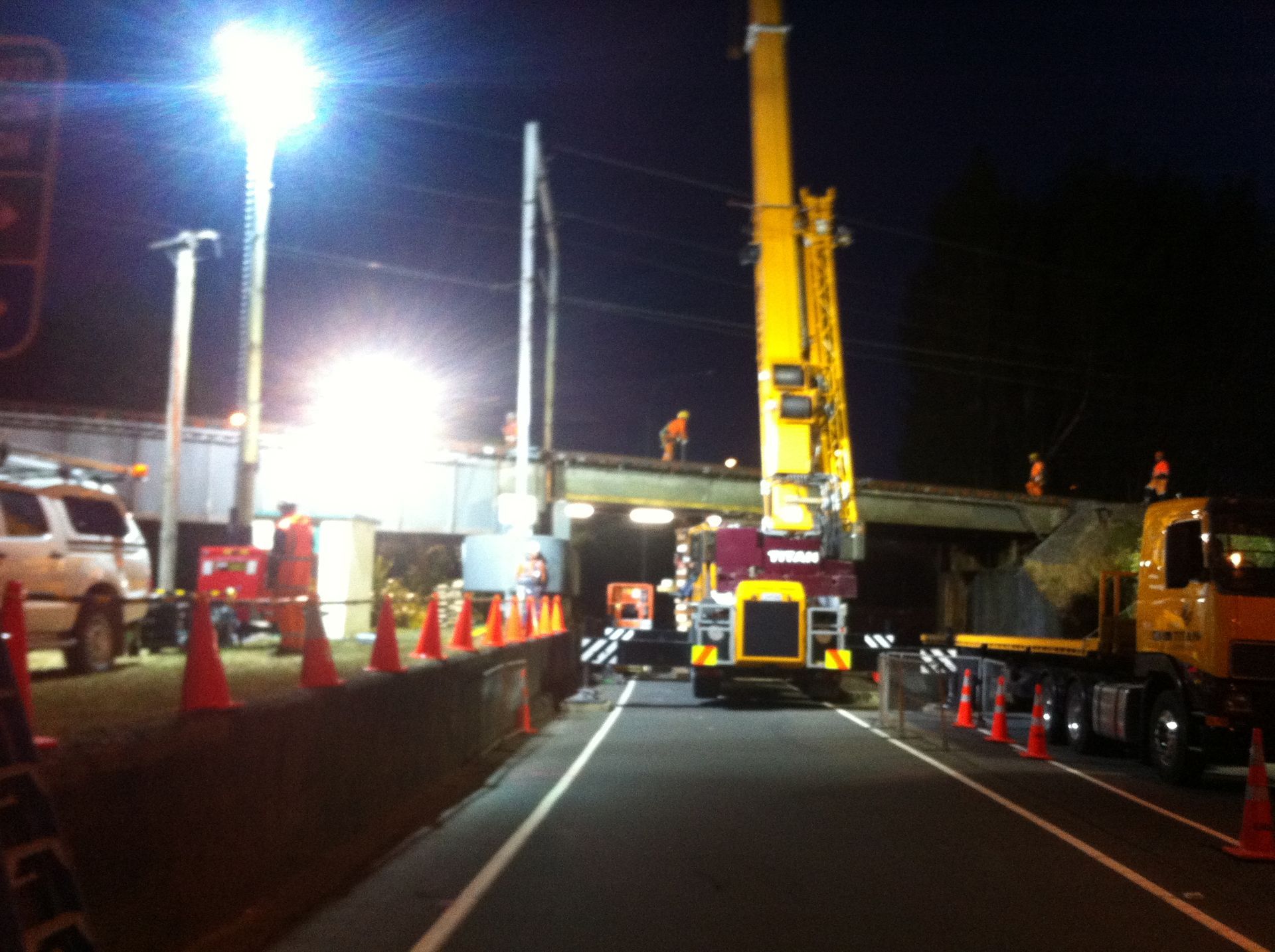 A yellow truck is parked on the side of the road at night