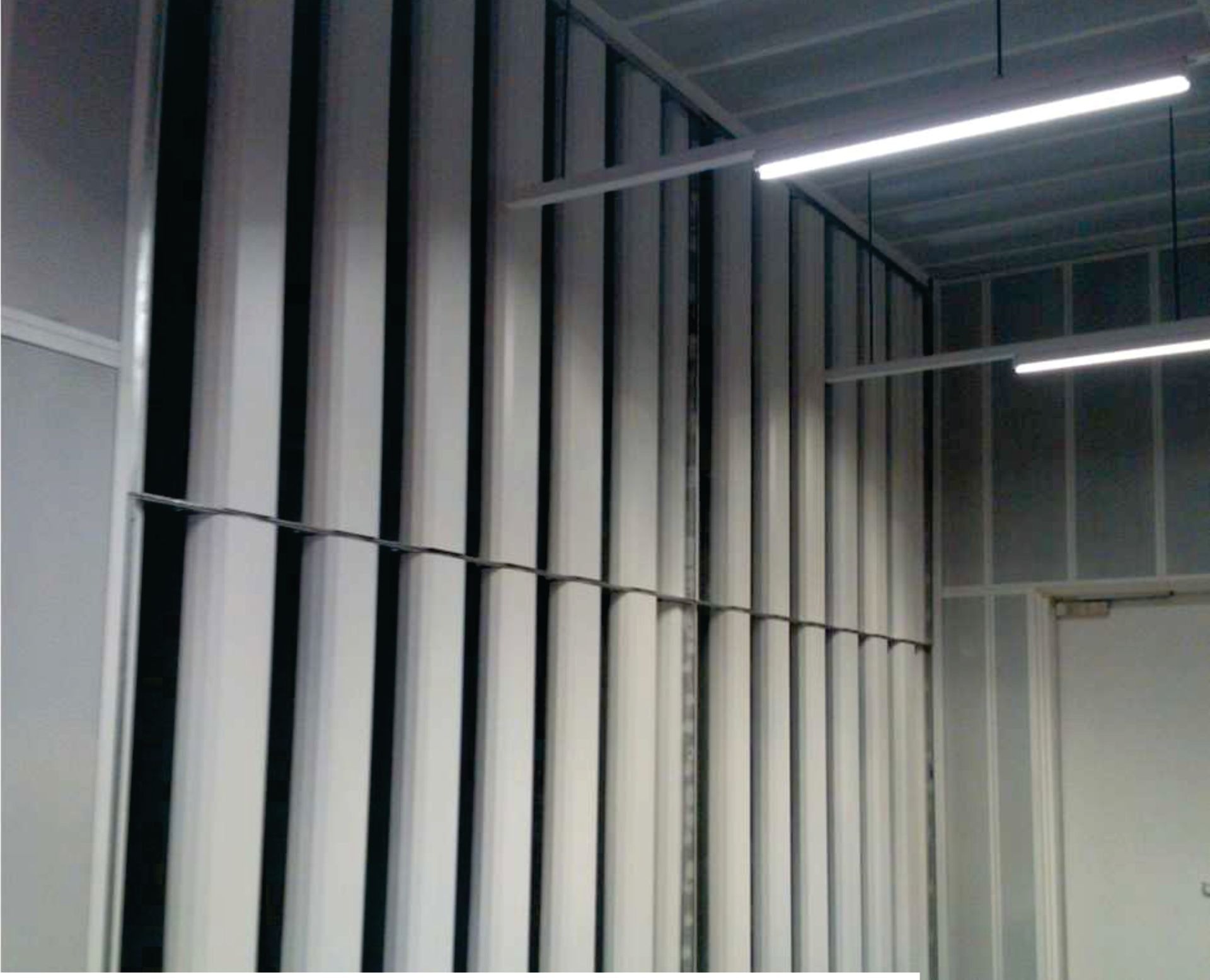 A room with a lot of white pipes on the wall