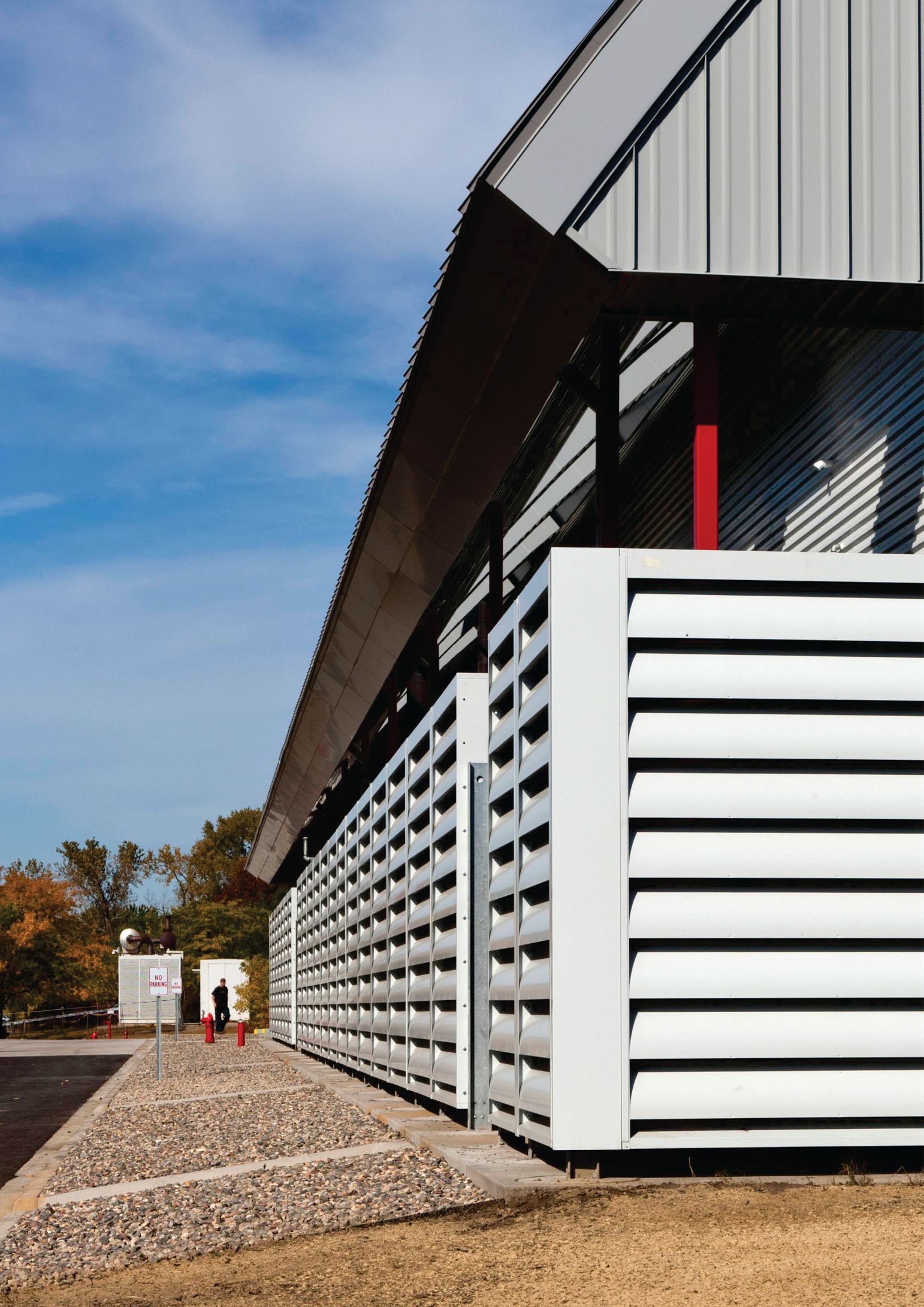 A building with a gray roof and white shutters on the side