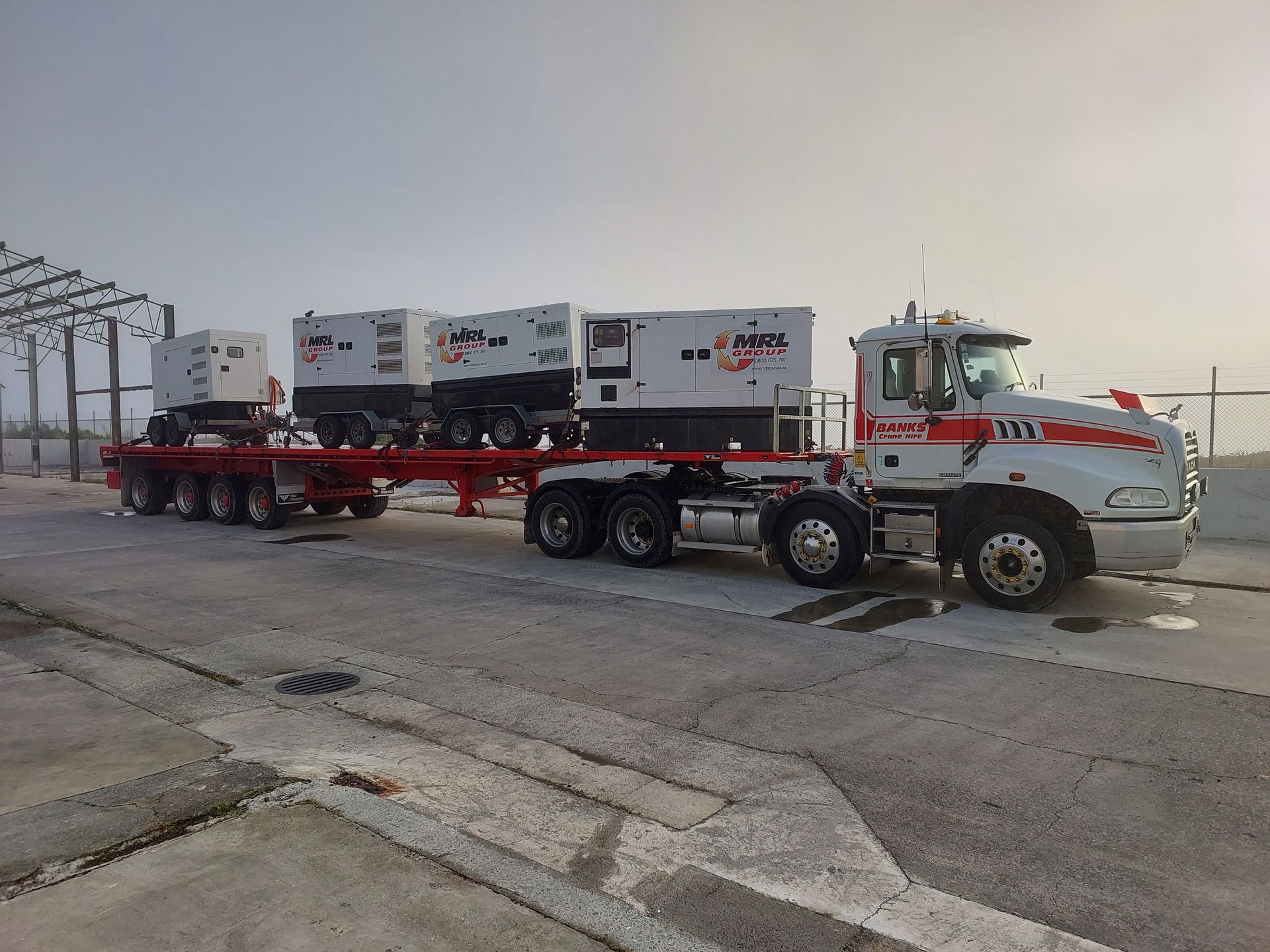 A semi truck is pulling a trailer with generators on it.