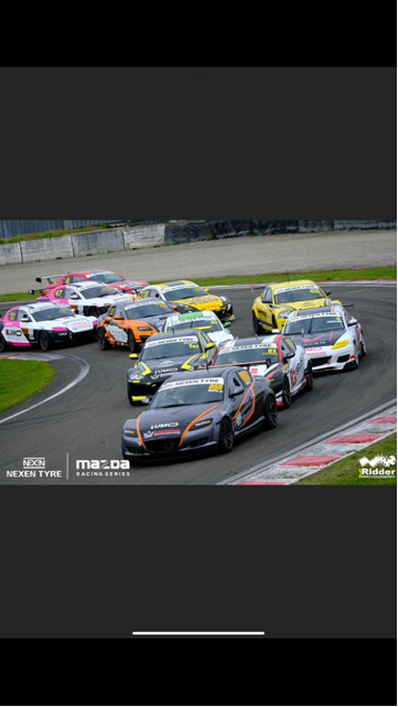 A group of cars are racing on a race track.