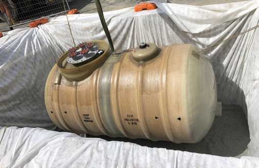 A large wooden barrel is sitting on top of a white tarp.