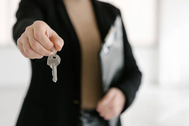 A Woman Holding A Key In Her Hand — Thornton, CO — Thornton Westminster Locksmith