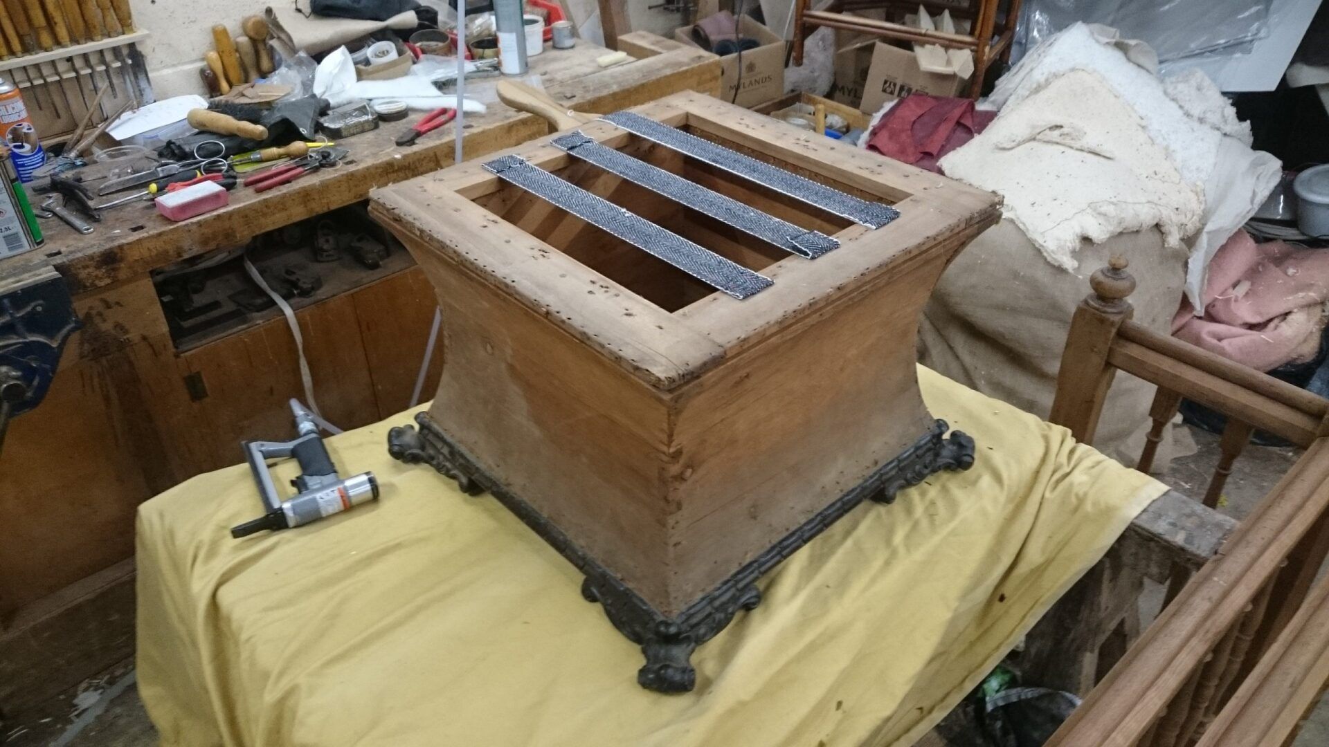A wooden box is sitting on top of a yellow table cloth.