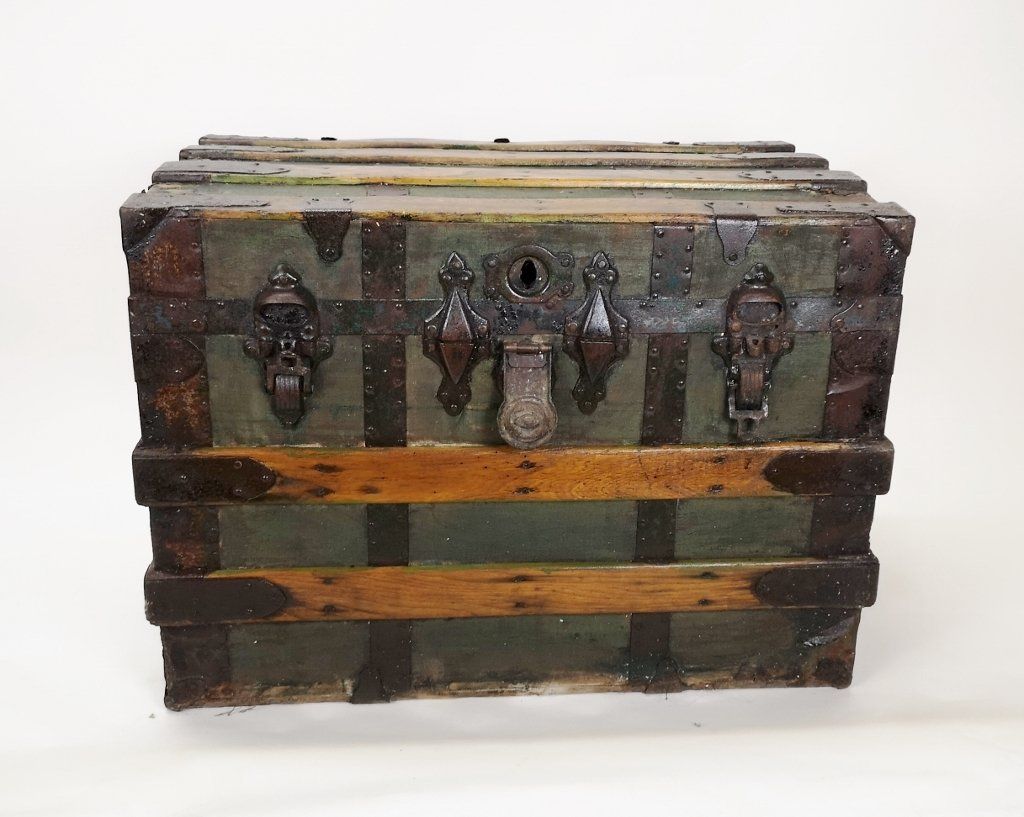 A wooden trunk with a lock on it is sitting on a white surface.
