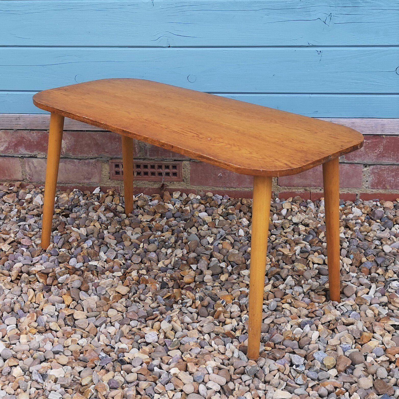 A small wooden table is sitting on a pile of gravel