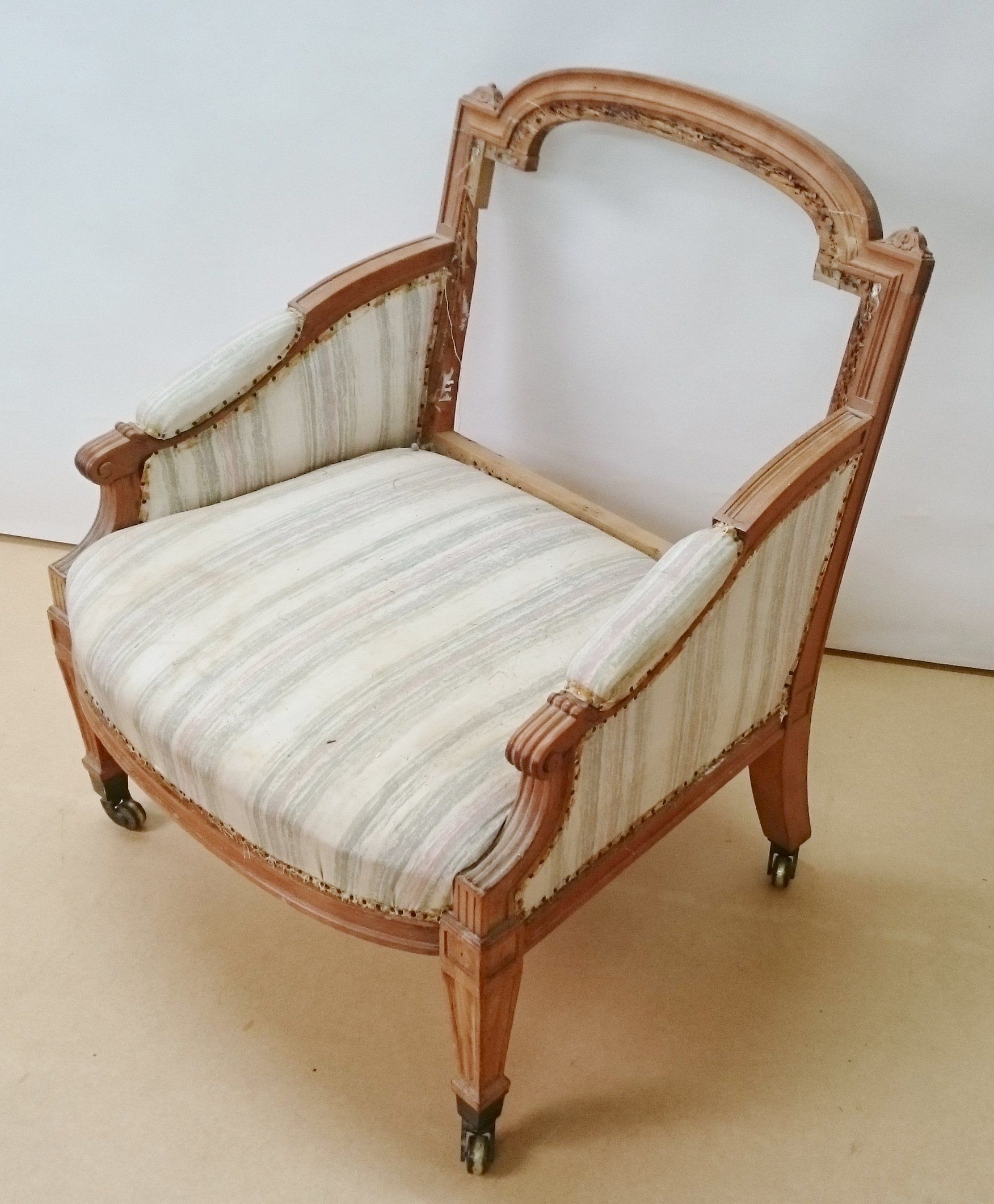 A wooden chair with a striped cushion and wheels