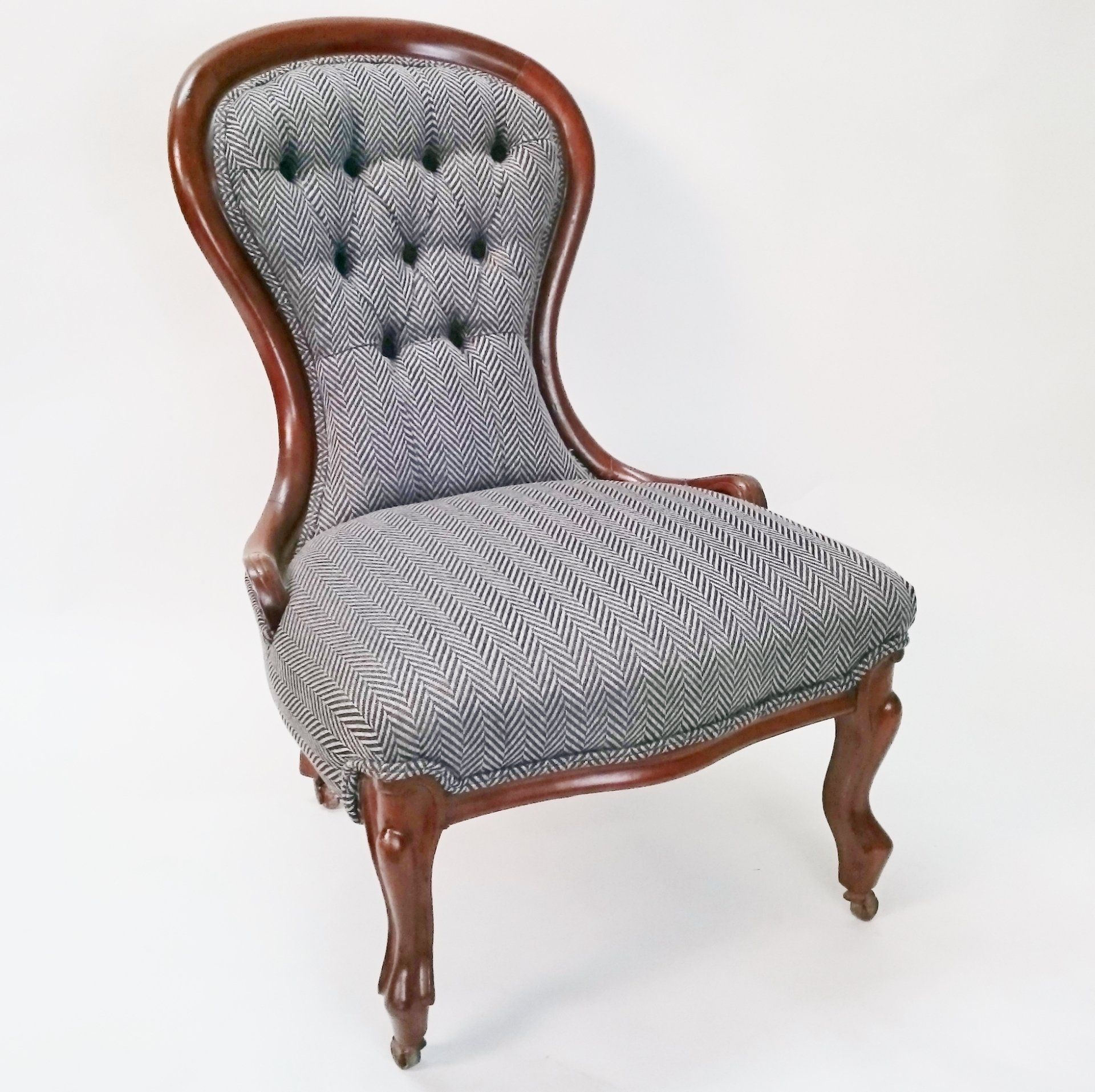A chair with a wooden frame and a gray cushion