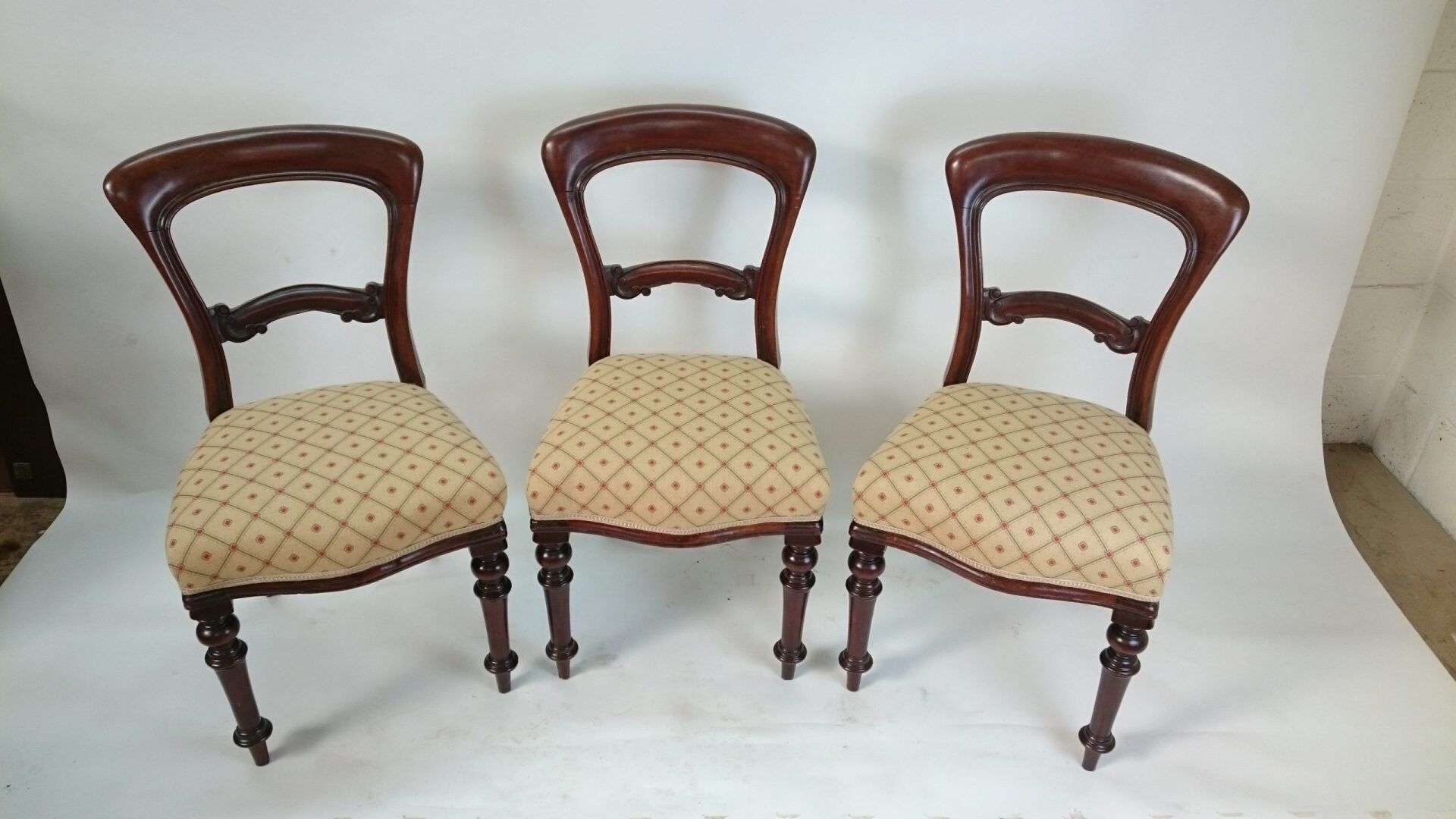 Three chairs are sitting next to each other on a white surface