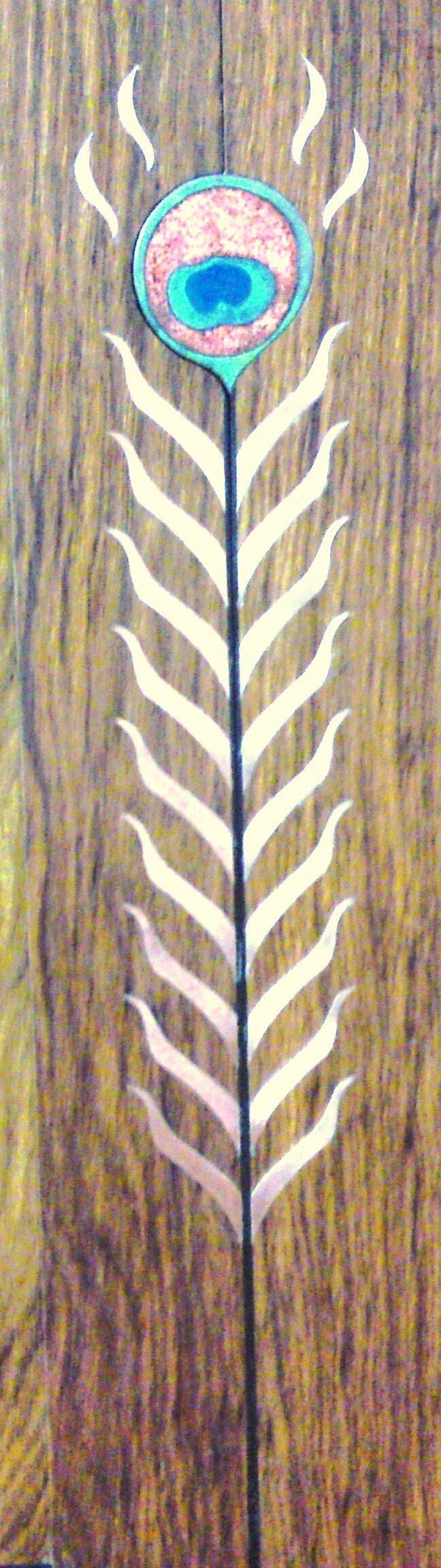 A peacock feather is painted on a wooden surface.