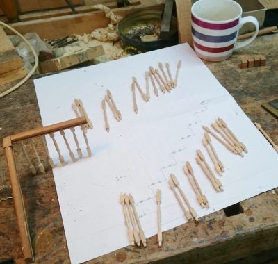 A striped mug sits on a table next to a piece of paper with sticks on it