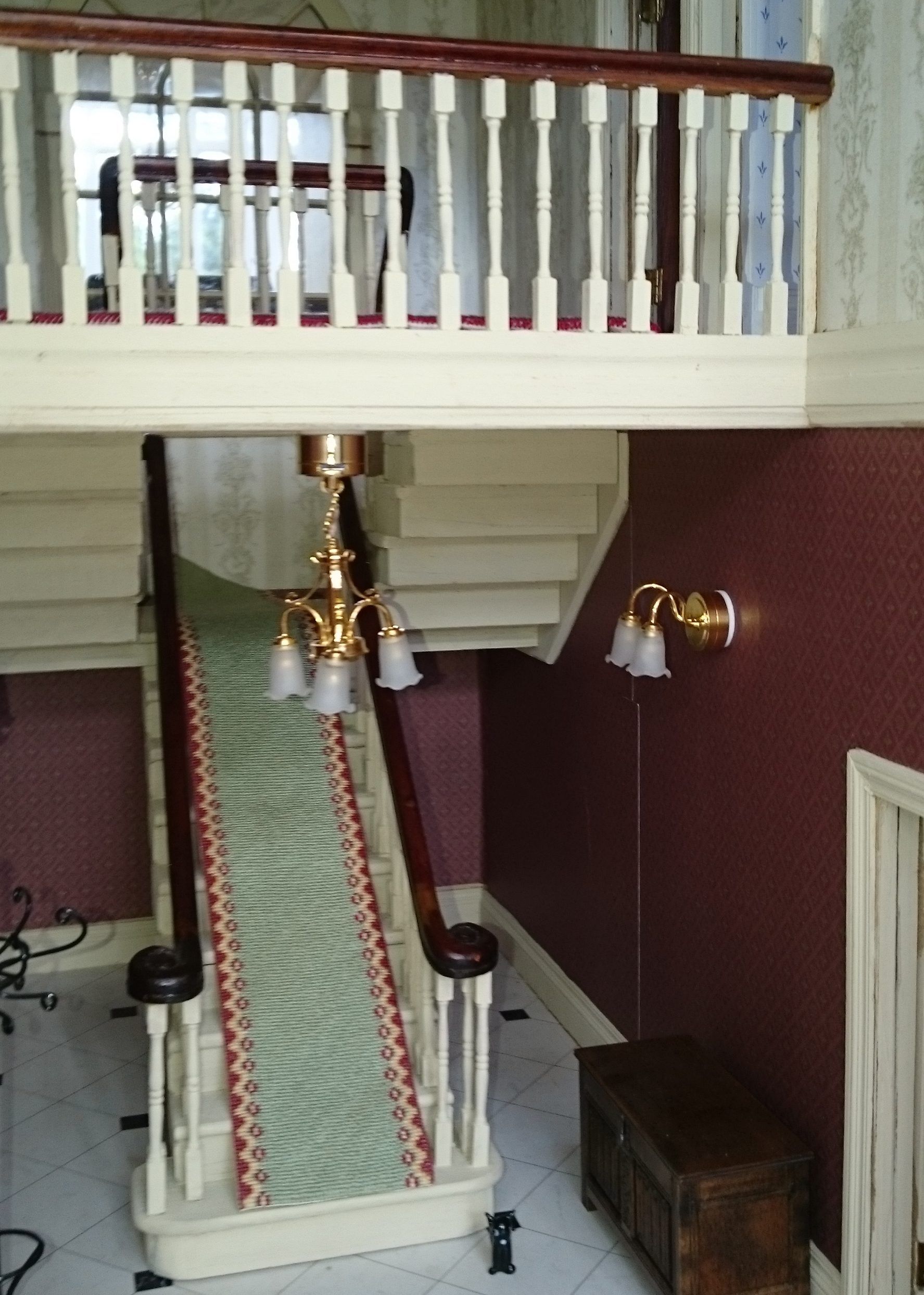 A doll house with a staircase and a balcony