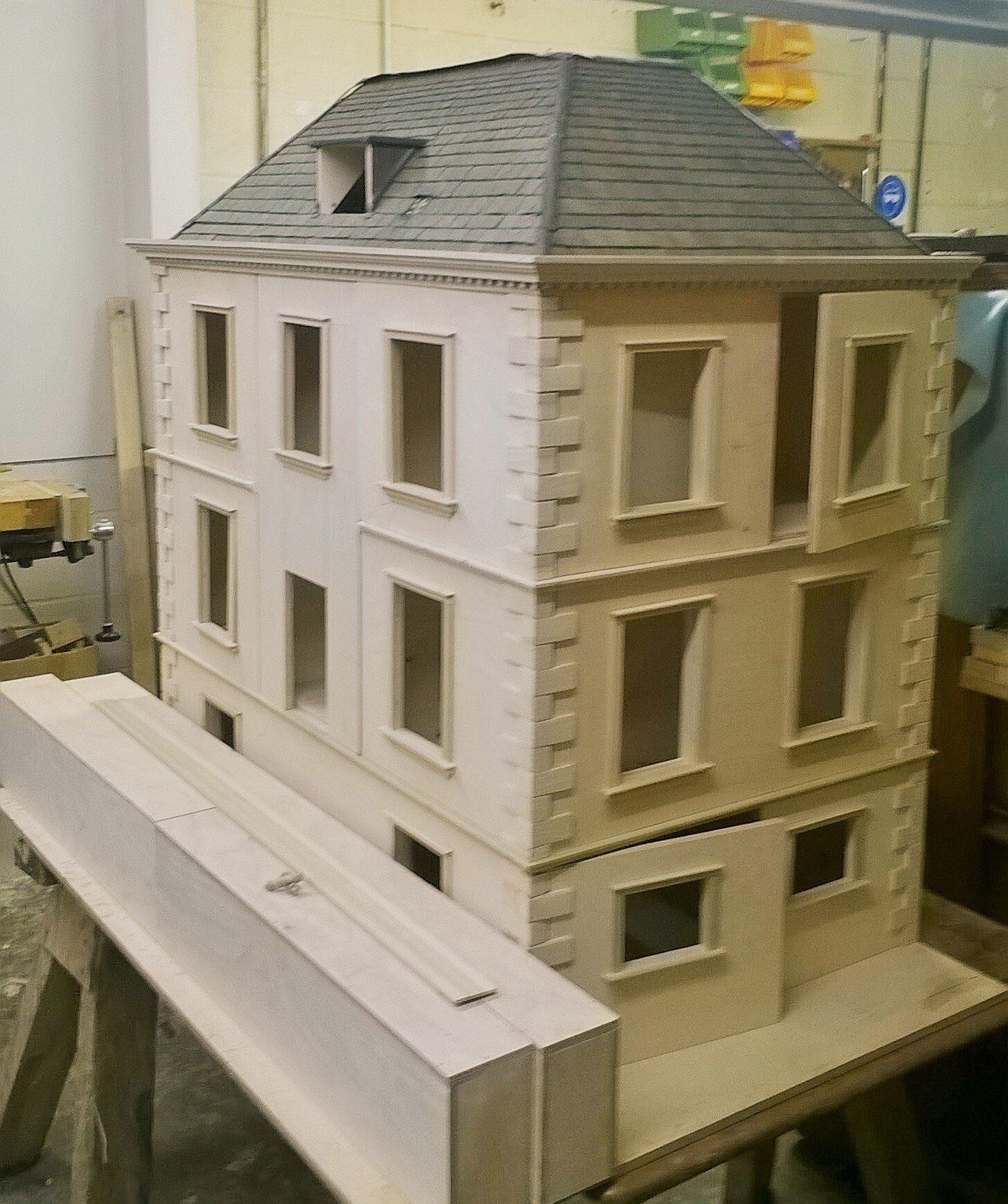 A doll house is sitting on top of a wooden table.