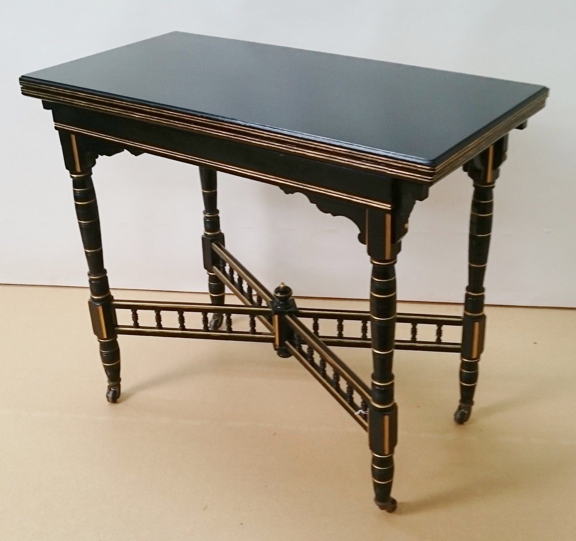A small table with a black top and gold trim