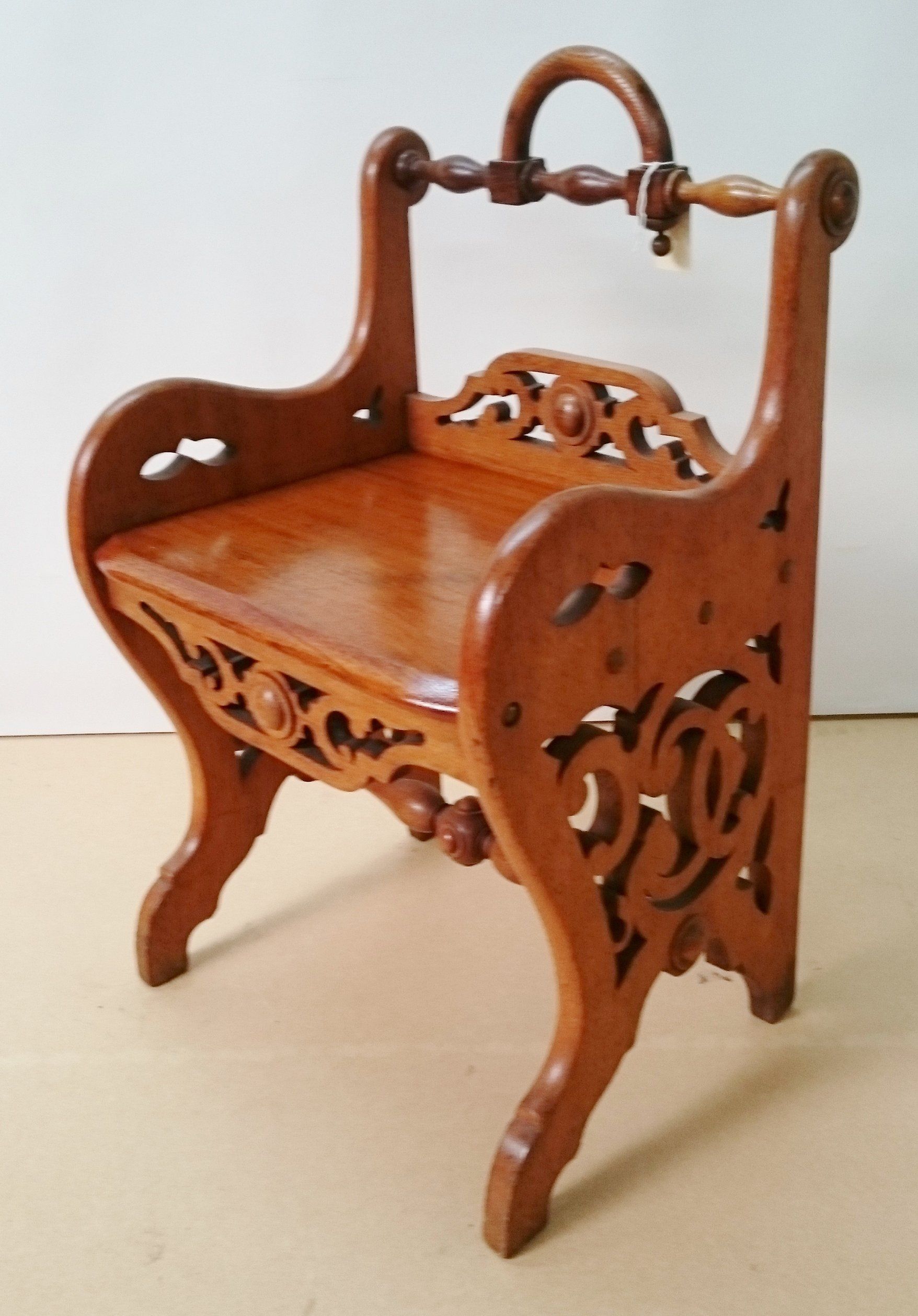 A small wooden chair with a handle on the back