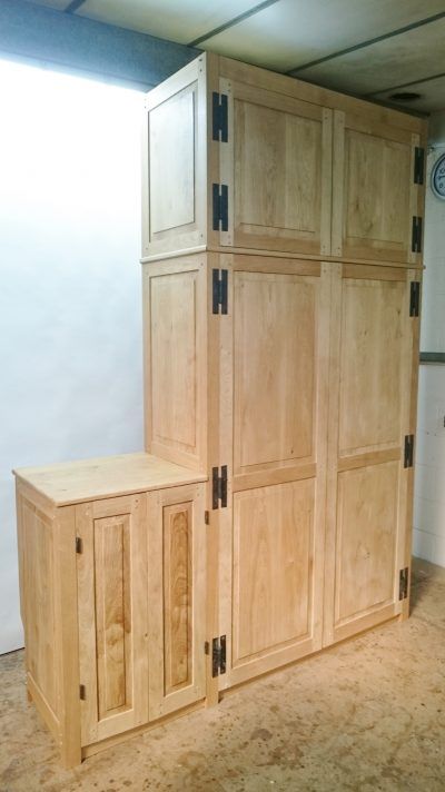 A room with a lot of wooden cabinets and a clock on the wall.