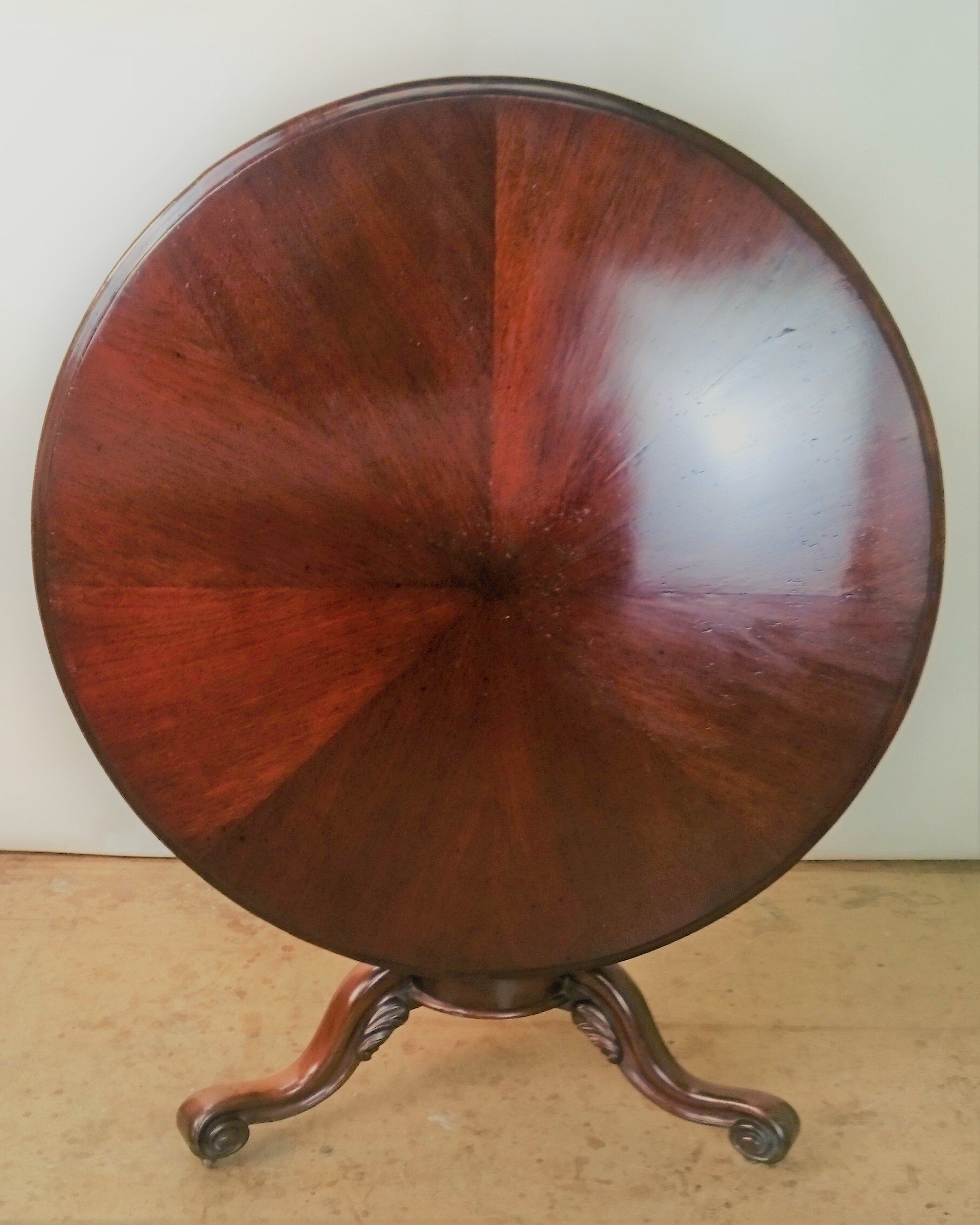 A round wooden table with a circular design on the top