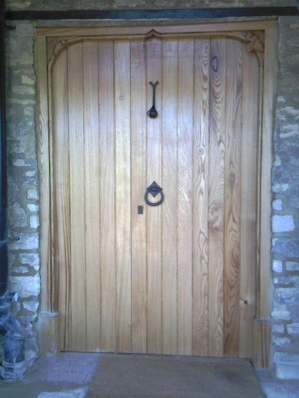 A wooden door with a door knocker hanging from it