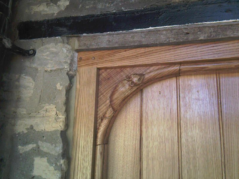 A close up of a wooden door with a stone wall in the background