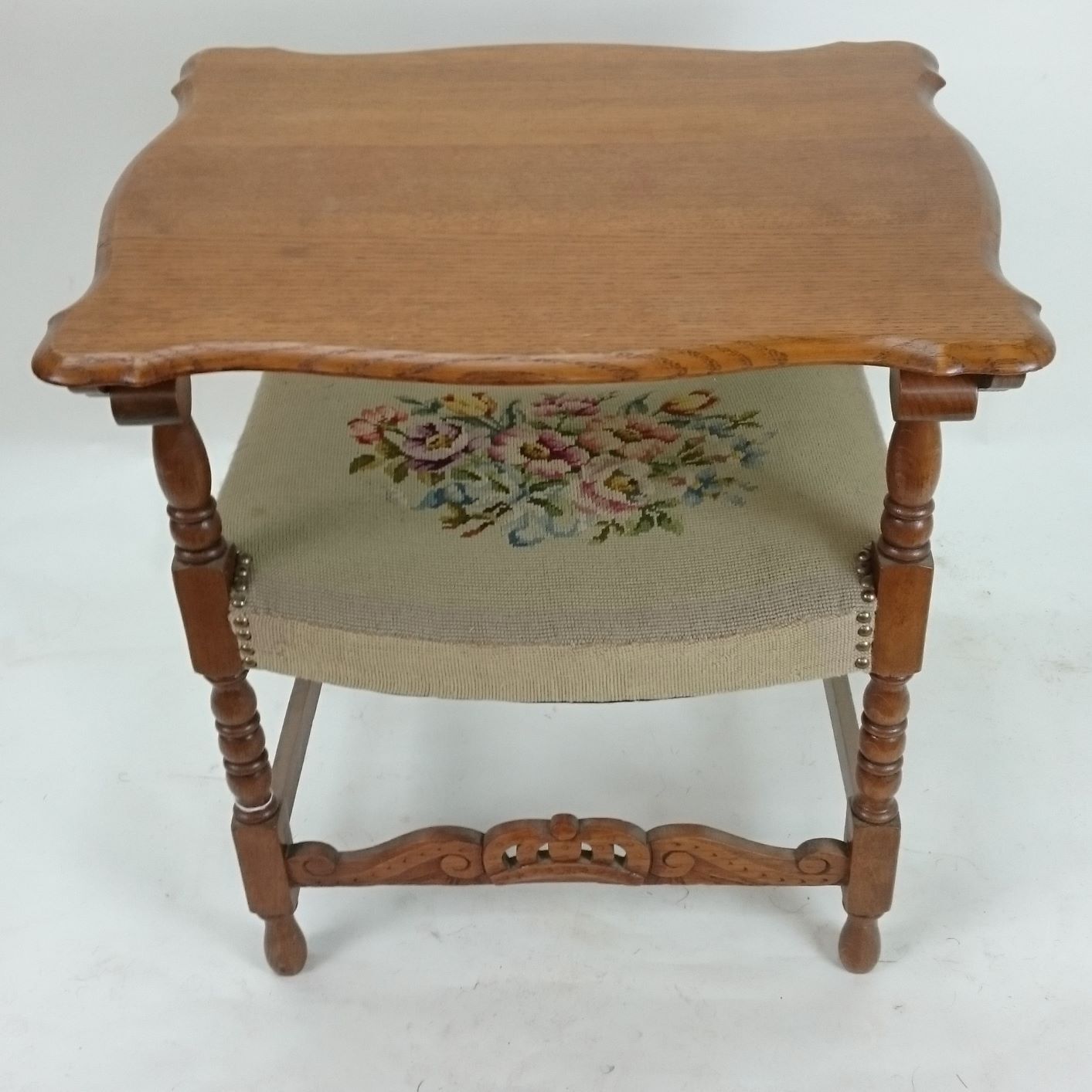 A wooden table with a floral embroidered seat