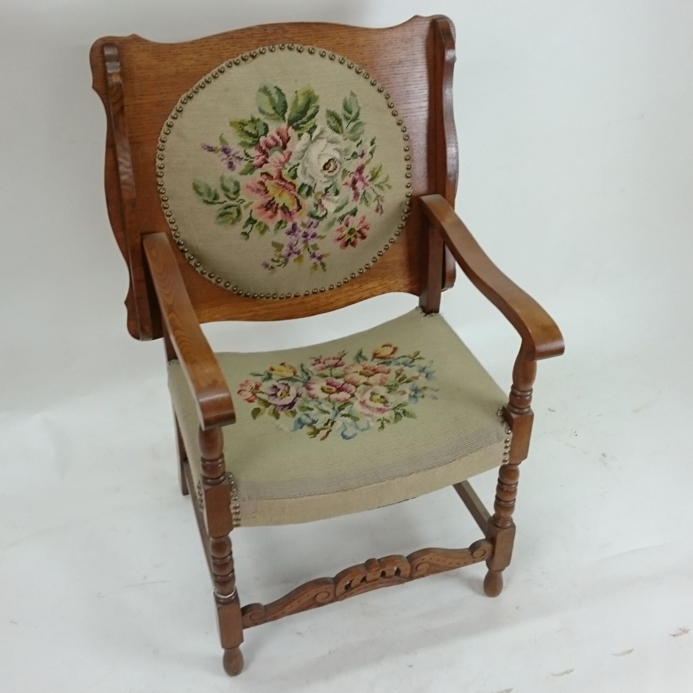 A wooden chair with a floral embroidered seat