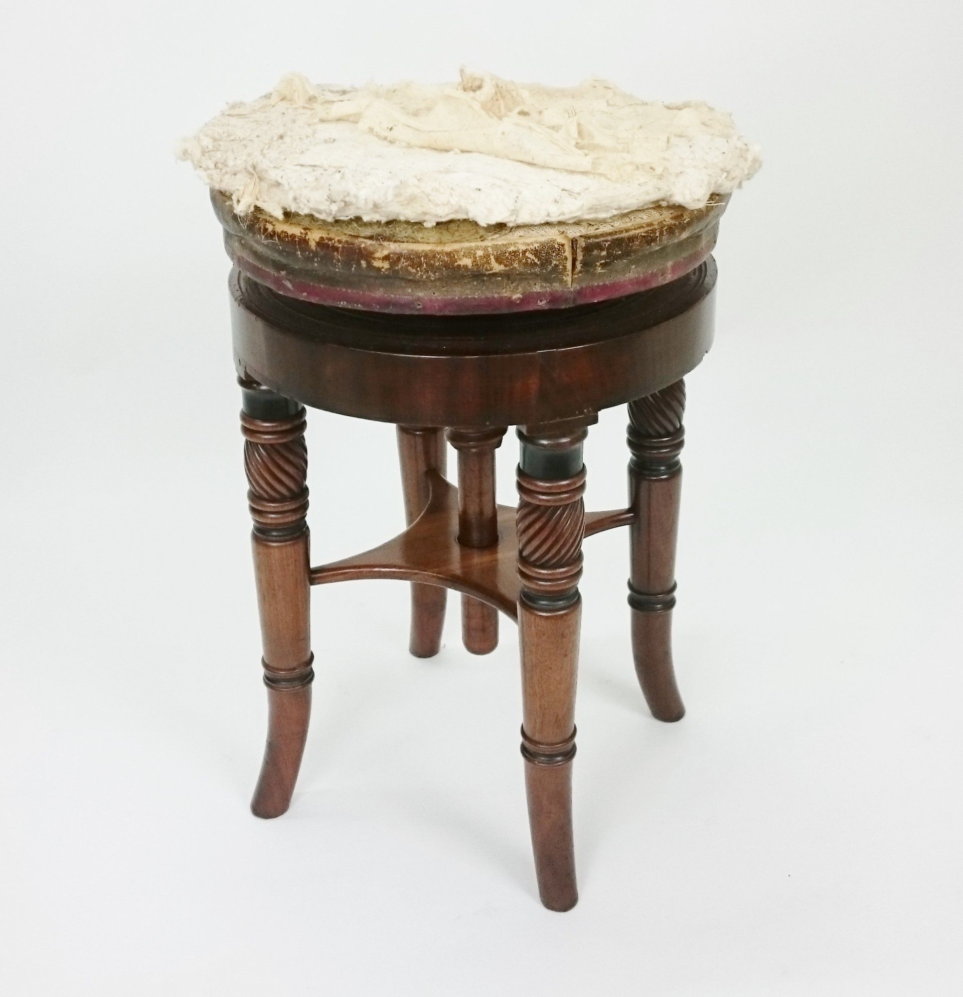 A wooden stool with a white cushion on top