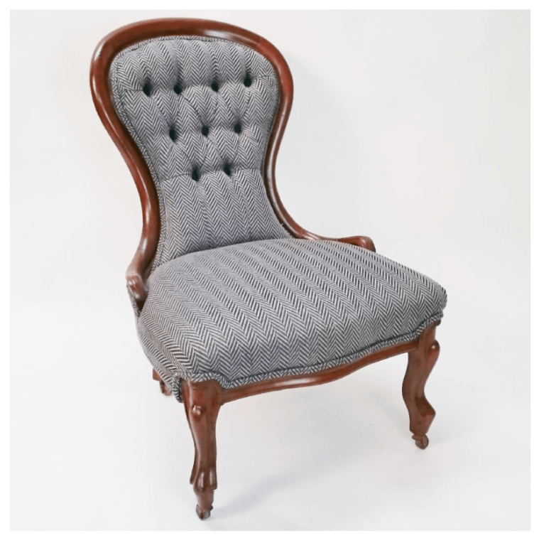 A grey chair with a wooden frame is sitting on a white surface